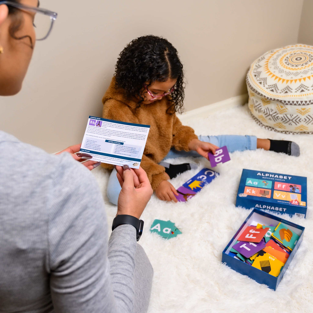 Black Mother Using ABSee Me’s Culturally Relevant Black Culture Alphabet Puzzles to Help Her Daughter Develop Letter Recognition 